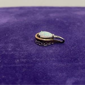 Sterling silver and 10K pear shaped simulated opal pendant.